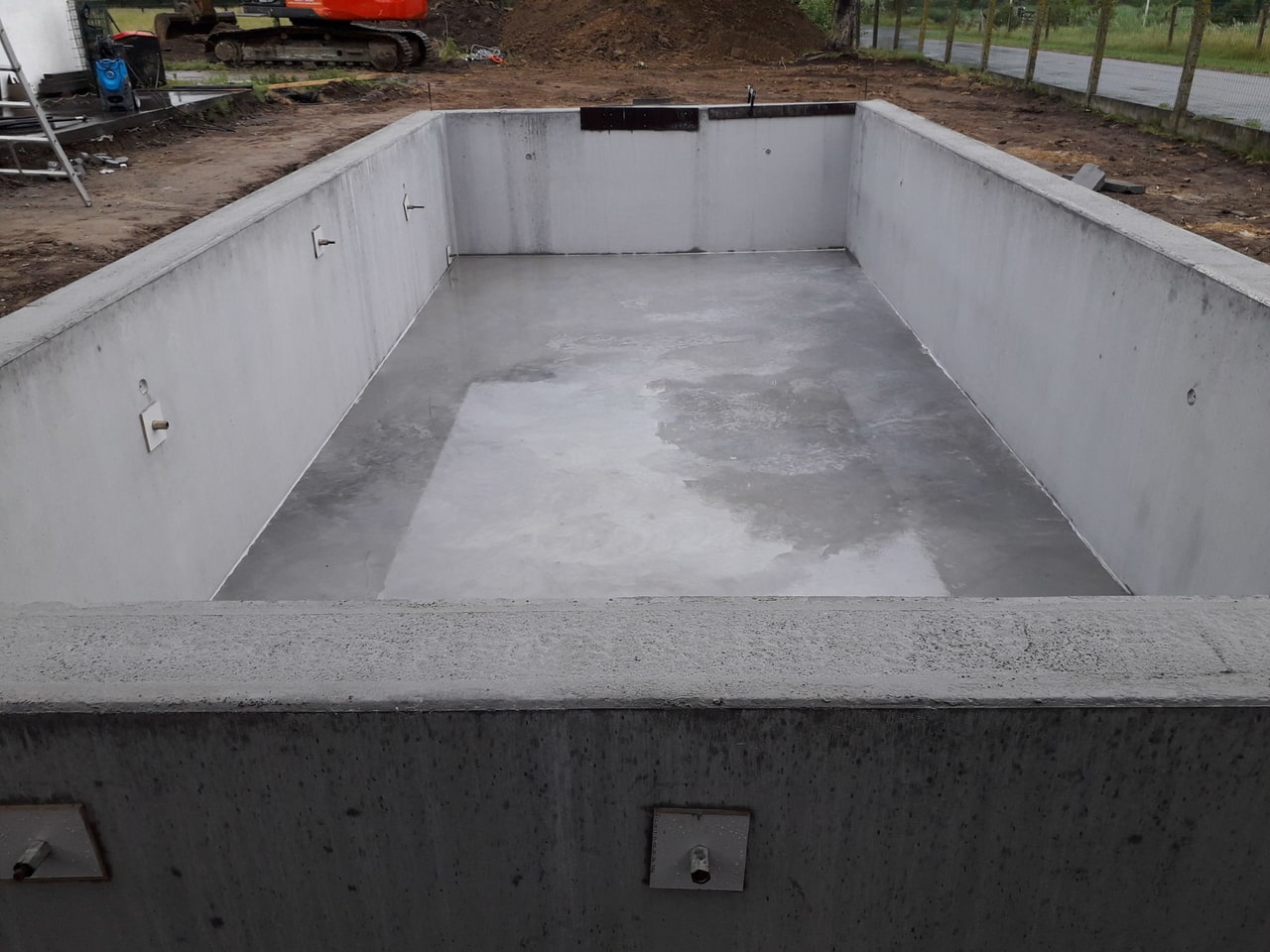 Aanleg van een betonnen zwembad in een nieuwe tuin door IZI POOL
